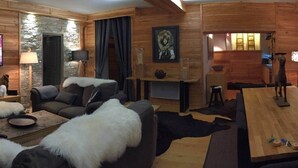 Ein gemütliches Wohnzimmer mit Kamin, Fernseher und Essbereich mit Tisch und Stühlen.