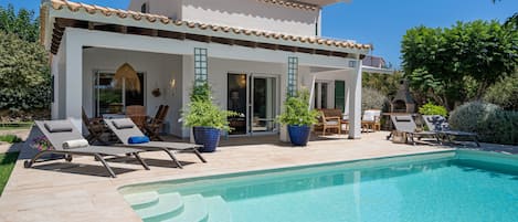 Alberca al aire libre y camastros