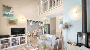 Un salón amplio con televisor, estanterías, un sofá y una chimenea.