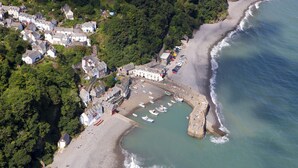 An aerial view of a coastal town with a sandy beach, a stone pier, and several boats docked at the pier. - 5 bedroom accommodation in Atherington, near Umberleigh (Atherington, near Umberleigh)