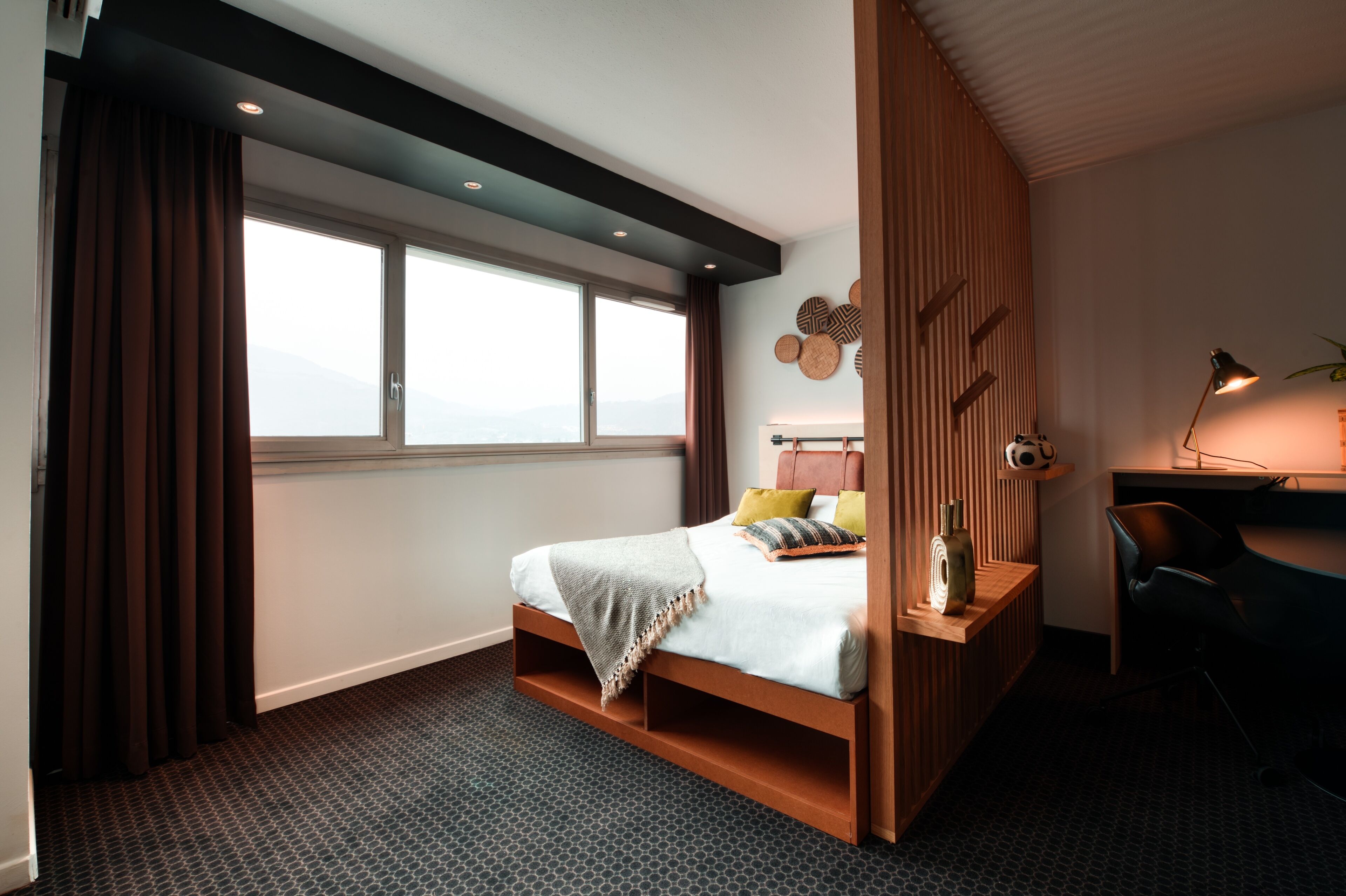 Een moderne slaapkamer met een bed, een bureau en een stoel.