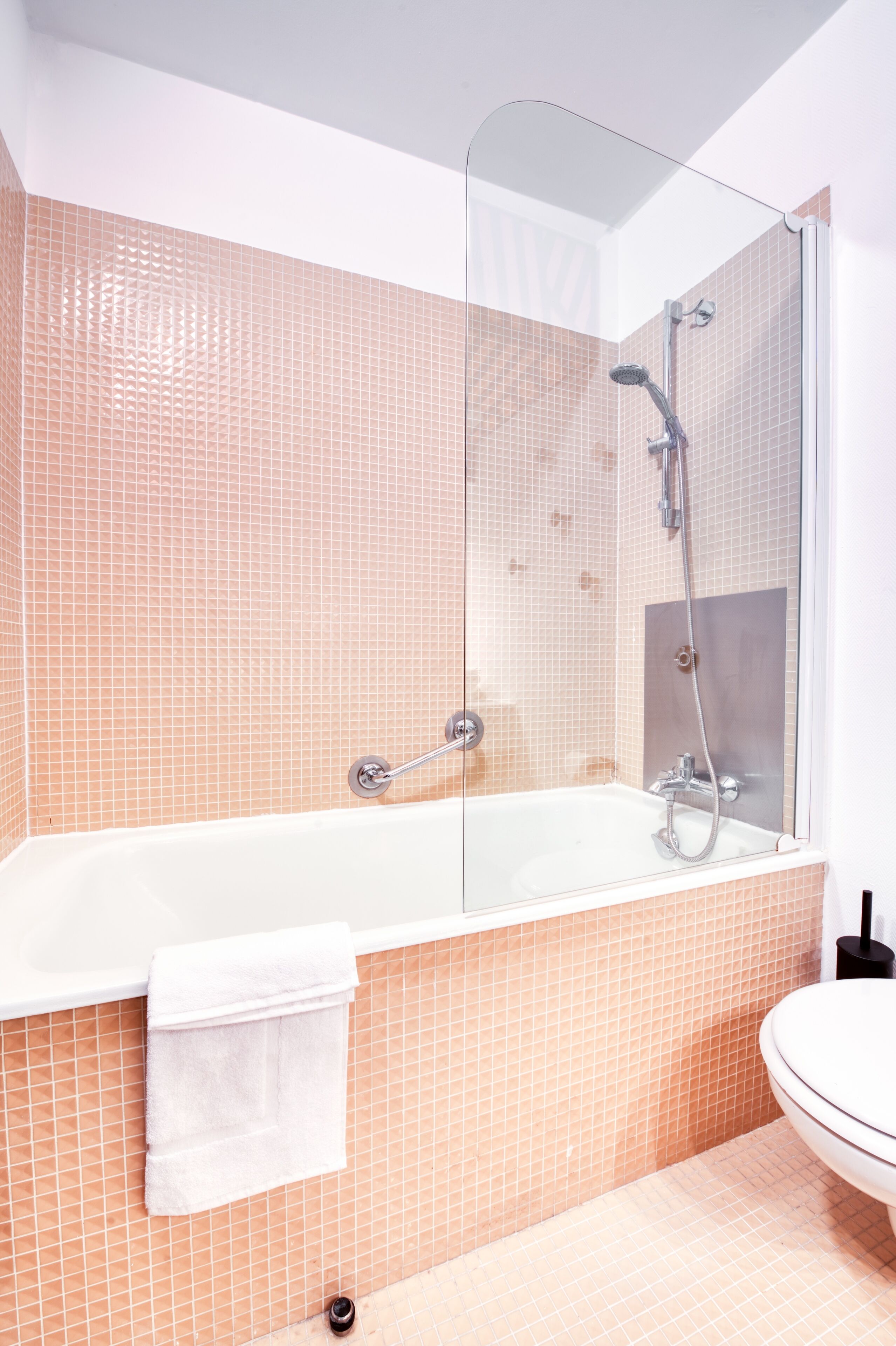 Un baño con ducha de vidrio, una bañera blanca y un lavamanos blanco.