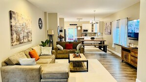 A spacious living room with a sofa set, a coffee table, and a TV. - Romantic Villa (Troy)