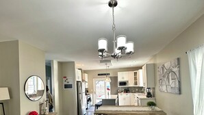 A spacious living room with a large sofa, a wooden coffee table, and a chandelier. - Romantic Villa (Troy)