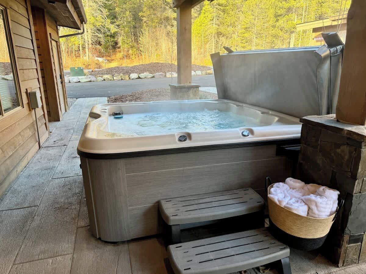 Ein Whirlpool mit einer Holzbank und einem Steinkamin.