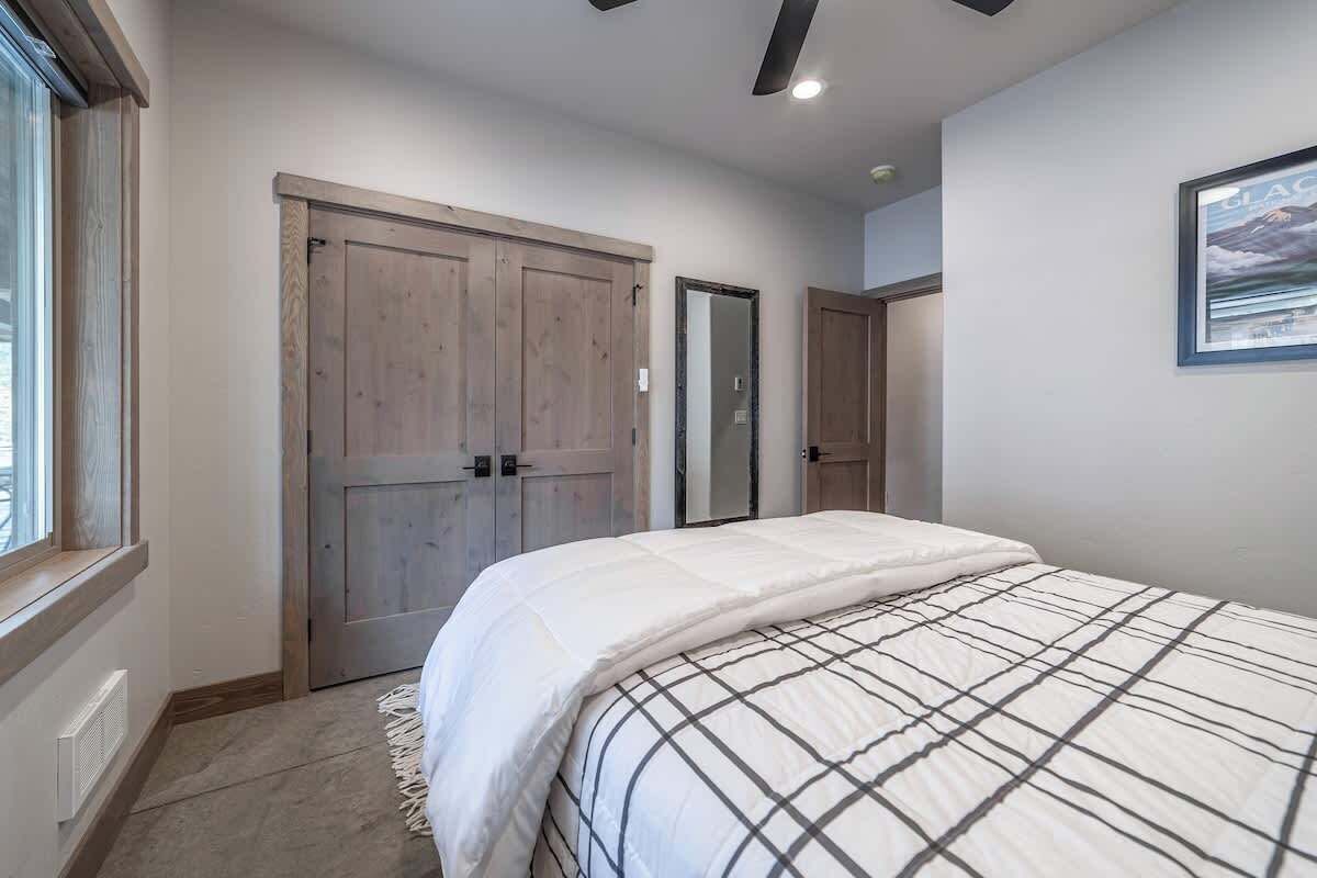 Une chambre avec un grand lit, une armoire et une porte.