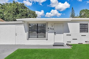 Stylish building with a clean design, featuring a large window and a well-manicured lawn.
