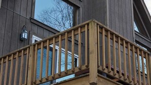 Un edificio moderno con ampie finestre e un terrazza in legno.