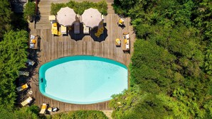 An aerial view of a wooden deck with a swimming pool, surrounded by lush greenery. - Villa Corallina 12, Emma Villas (Marina di Bibbona)