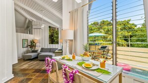 Un comedor con una mesa de vidrio, sillas y vistas al exterior.