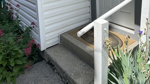 Ein Haus mit weißer Fassade, einer grauen Haustür und der Hausnummer 2.