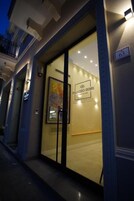 La entrada de un hotel con puerta de vidrio, un cartel que dice "Palazzo Bibbi" y el número "63" en la pared.