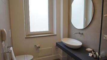 A modern bathroom with a toilet, bidet, and a vanity with a mirror.