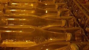 A close-up of clear glass bottles arranged in a grid pattern, likely in a storage or manufacturing setting. - le Flaubert (Villenauxe-la-Grande)