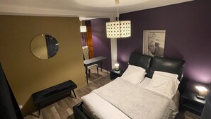 A hotel room with a bed, a bench, a desk, and a chair. - le Flaubert (Villenauxe-la-Grande)