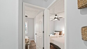 A bedroom with a bed, a ceiling fan, a nightstand, and a bedside table. - Casa Azul: Tranquility + Fire Pit + Gameroom + Peace (Fayetteville)