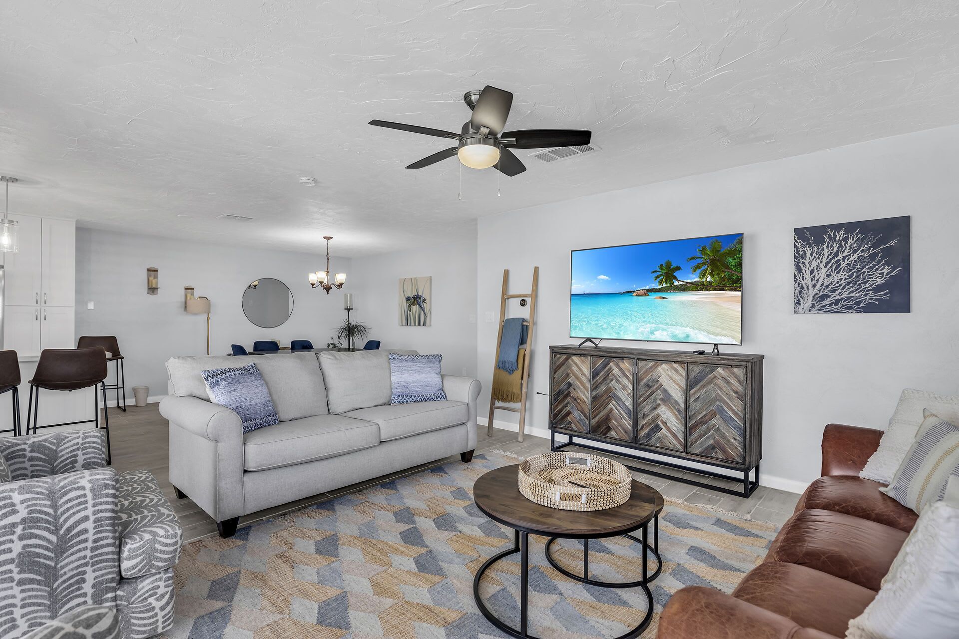 Una sala de estar con sofá, mesa de centro y televisor que muestra una escena de playa.