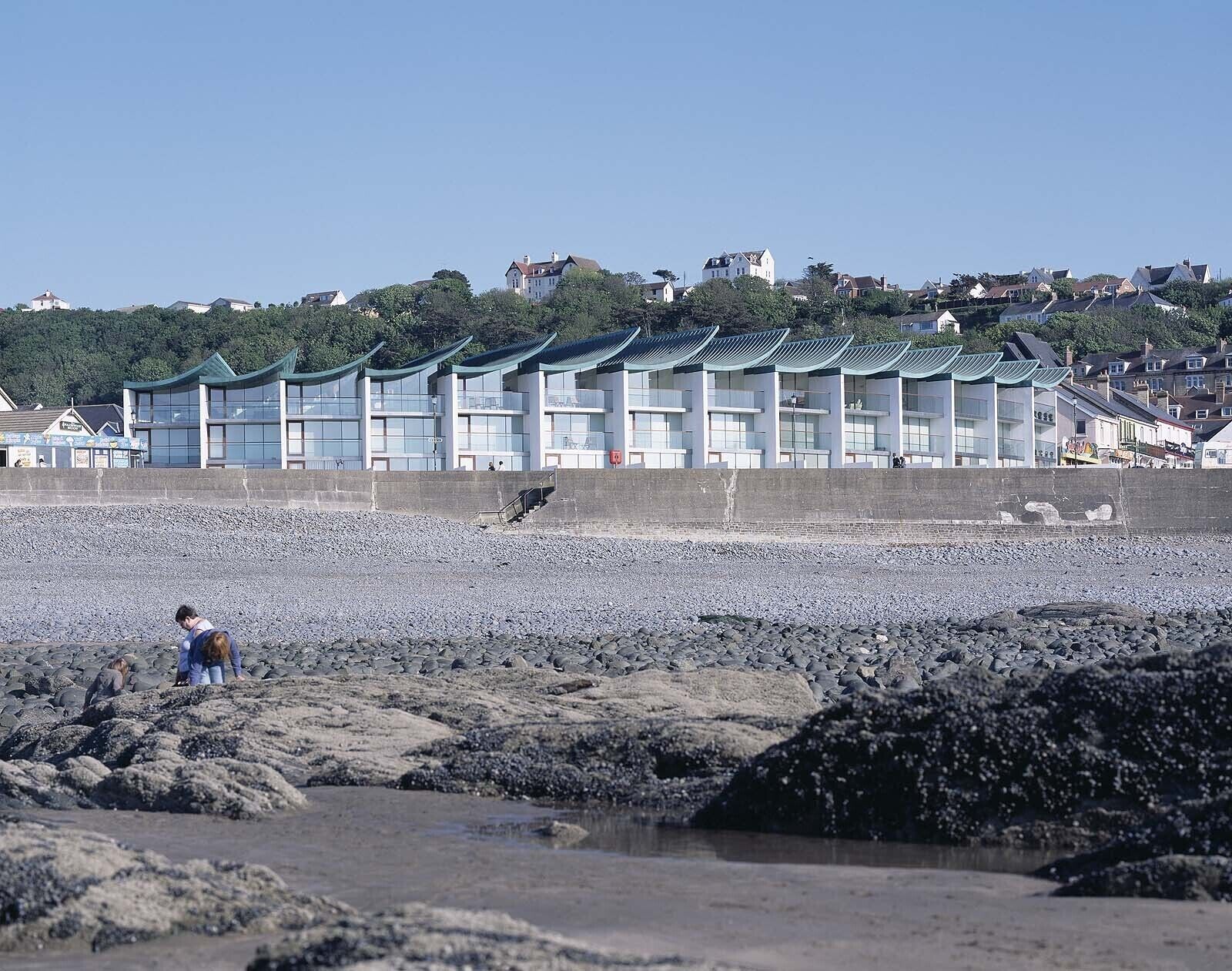 A coastal hotel with multiple-story buildings featuring large windows and a traditional architectural style.
