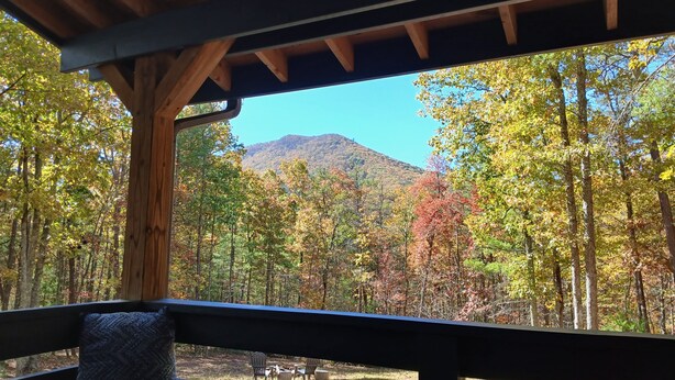 A wooden deck with a view of a forest and a mountain. -  Secluded ridge 
 top wilderness retreat with fast wifi and all the comforts  (Wytheville)