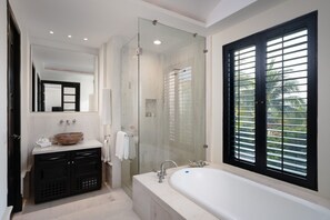 Ein modernes Badezimmer mit einer großen Badewanne, einer gläsernen Dusche, einem Waschtisch mit einer Schüssel und einem Fenster mit Jalousien.
