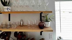 A kitchen with wooden shelves holding wine glasses, a potted plant, and a decorative wooden sculpture. - Newly Remodeled 3 Bed 2 Bath home, minutes from everything (Pendleton)