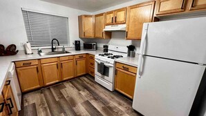 A kitchen with wooden cabinets, a white refrigerator, a stove, and a microwave. - Newly Remodeled 3 Bed 2 Bath home, minutes from everything (Pendleton)