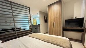 Une chambre d’hôtel équipée d’un lit, d’une télévision, d’une armoire et d’un bureau.