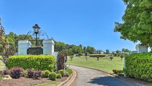 Der Eingang zu einem Golfplatz mit einem Schild für 'Cleighborn Golf Club', umgeben von gepflegten Hecken und blauem Himmel.