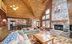 Cozy living area with a sofa set, stone fireplace, and mounted TV.