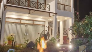Un bâtiment à deux étages doté d’un balcon et d’un foyer au premier plan.