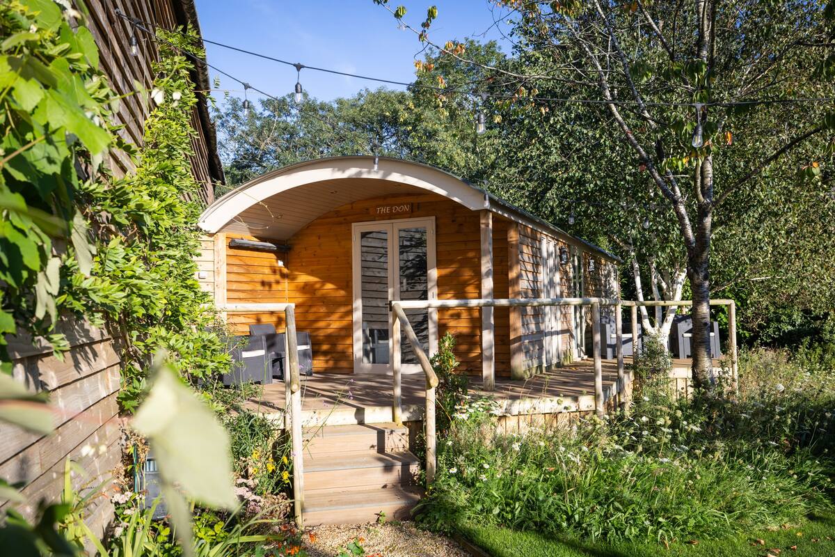 A wooden cabin with a porch and a staircase leading to the entrance.