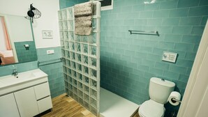 A bathroom with a shower, toilet, and sink. - .................... (AN)