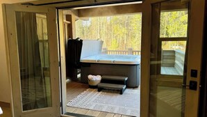 Wellnessbereich mit Whirlpool, kleiner Bank und einer Korb mit Handtüchern.