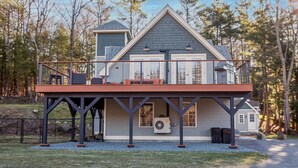A two-story house with a balcony, a garage, and a small shed.