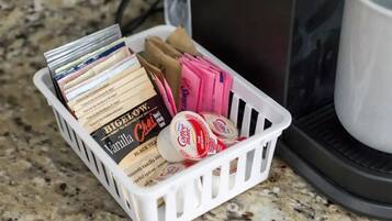 A basket containing tea bags and coffee pods on a kitchen counter.