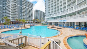 Un hotel con un amplio área de piscina, múltiples niveles de balcones y un letrero que dice "North Tower".