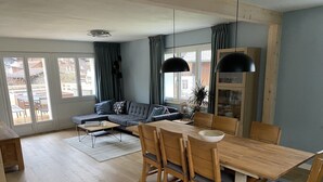 Un saló modern amb un sofà, una taula de menjador i cadires.
