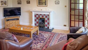A living room with a television, fireplace, and two sofas.