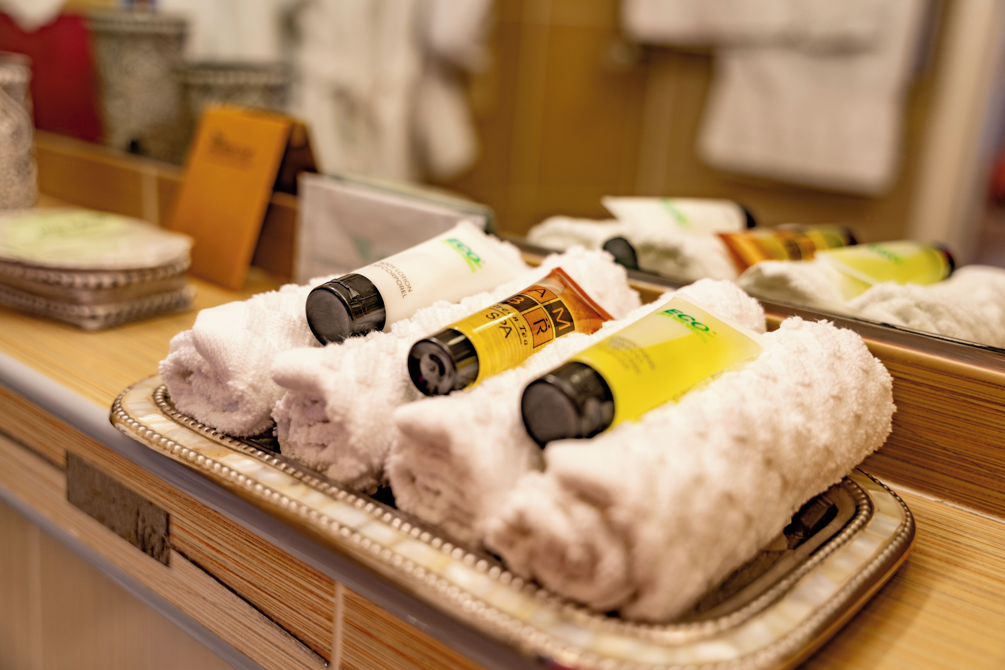 A display of toiletries including towels and bottles of shampoo and conditioner.