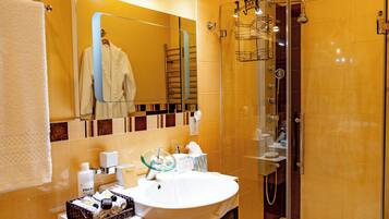 Un baño moderno con ducha de vidrio, un lavamanos blanco y un espejo sobre él.