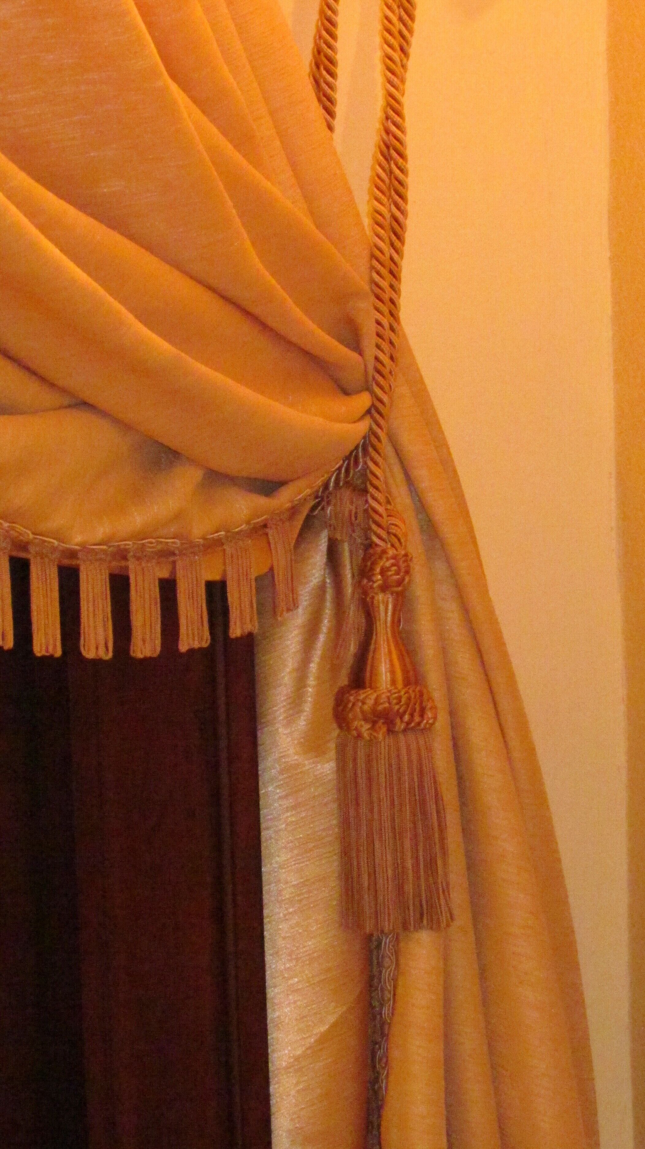 A close-up of a curtain with a tassel detail.