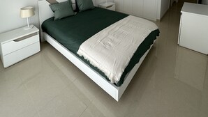 A modern bedroom with a bed, nightstands, a wardrobe, and a desk. - Apartment with 2 bedrooms 100 meters from the beach / New (Quarteira)