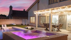A backyard with a hot tub, outdoor seating, and a covered patio area. - ❤ BRAND NEW POOL, Clean 4BR/3BA Modern Chic Home ❤ (Henderson)