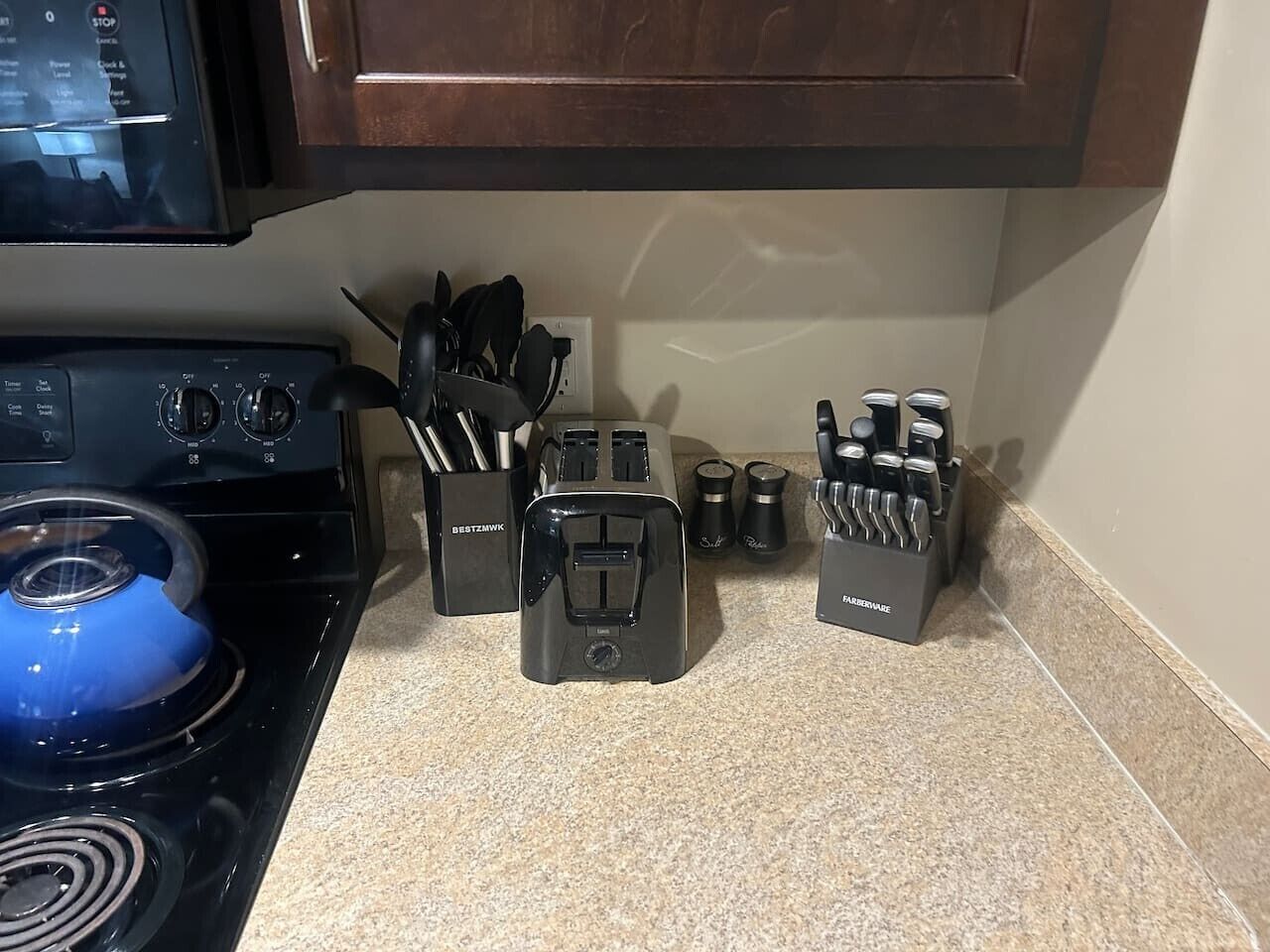 A kitchen with a stove, toaster, and knife block.