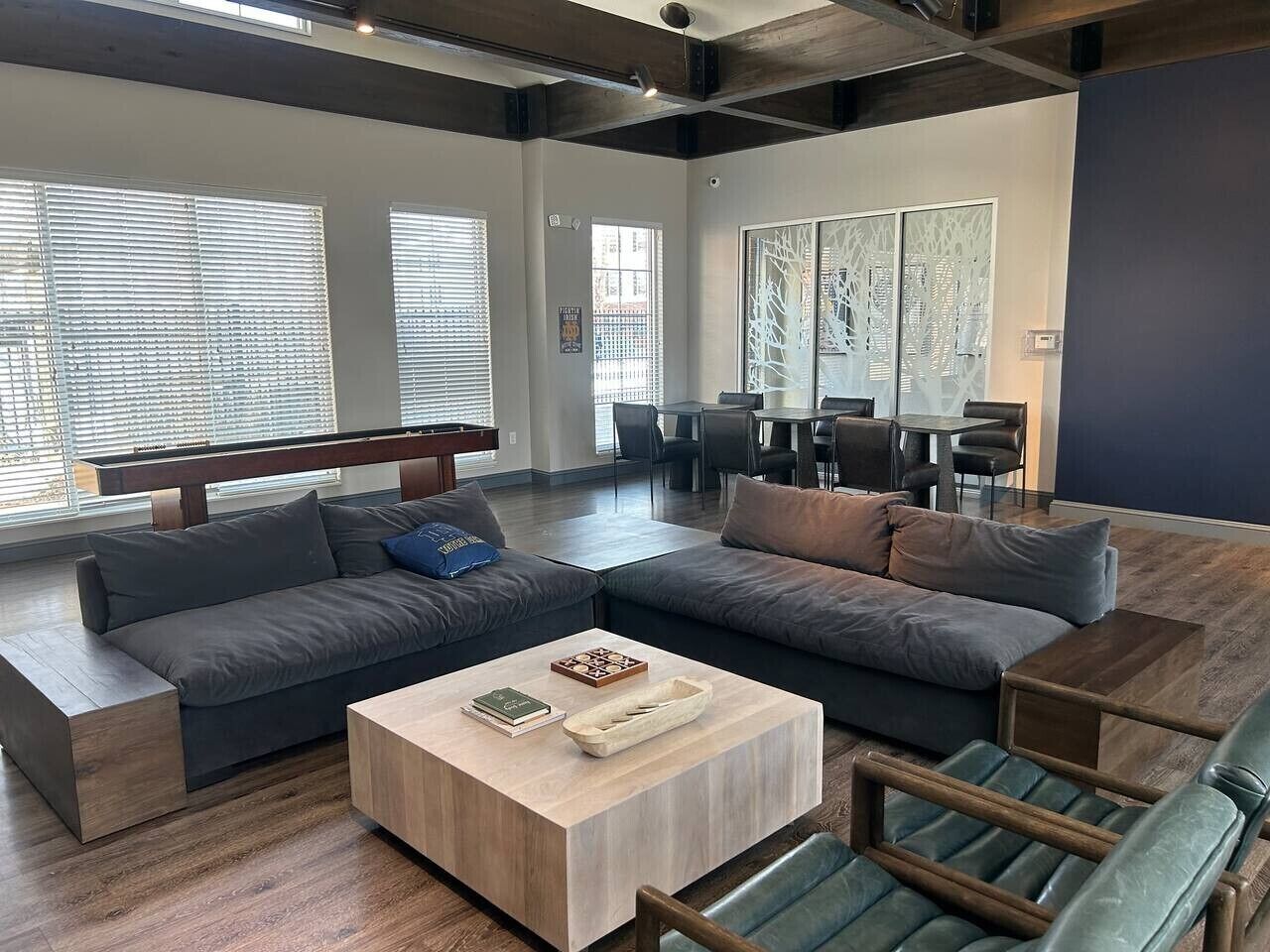 Ein modernes Wohnzimmer mit einem Ecksofa, einem Couchtisch und einem Essbereich mit Stühlen.