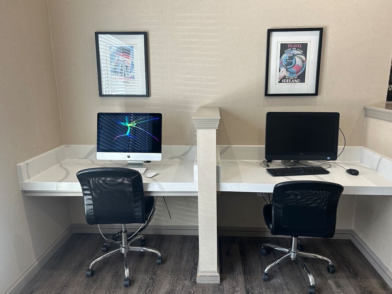 Un espacio de trabajo con dos escritorios, cada uno con un monitor de computadora, teclado y silla.