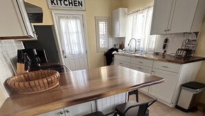Una cucina con isola in legno, due sgabelli da bar e un cartello con scritto 'KITCHEN'.