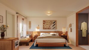 A bedroom with a bed, bedside tables, a nightstand, a lamp, a painting, a robe, and a bathroom door. - Oyster Estate (Greenport)