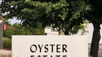 Une enseigne indiquant l’emplacement d’Oyster Estate, avec un arbre en arrière-plan.