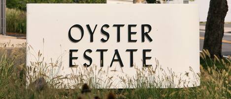 Letrero de Oyster Estate con un árbol al fondo.